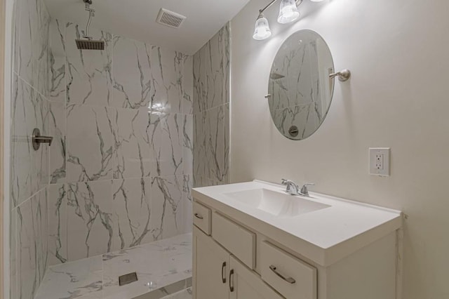 bathroom with vanity and a tile shower