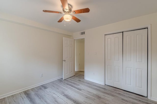 unfurnished bedroom with ceiling fan, light wood-type flooring, and a closet