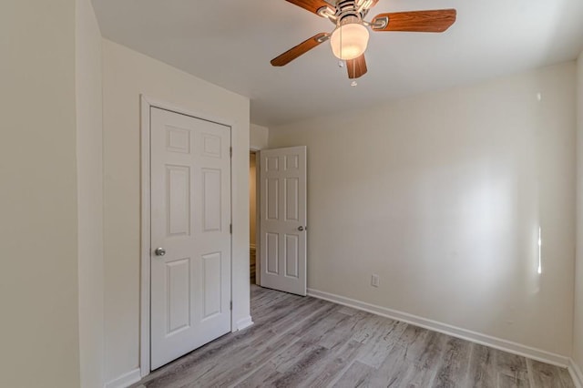 unfurnished bedroom with ceiling fan and light wood-type flooring