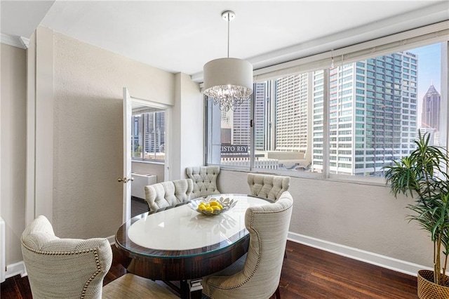 dining area with a wealth of natural light, a chandelier, and dark hardwood / wood-style floors