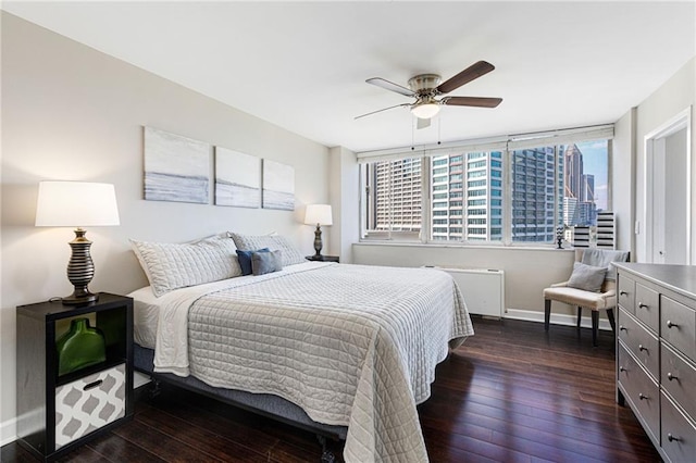 bedroom with dark hardwood / wood-style floors, radiator, and ceiling fan