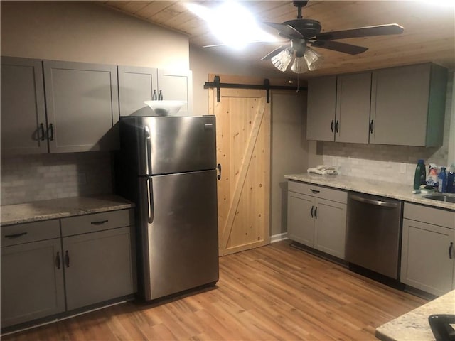 4744 Chickasaw Way SE, Acworth, GA 30102 - kitchen with stainless steel appliances, gray cabinets, a barn door, a ceiling fan, and light wood-style floors