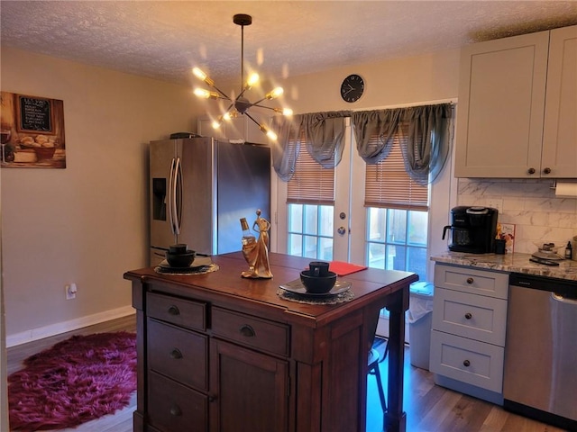 1625 Conley Rd Unit 229, Conley, GA 30288 - kitchen featuring stainless steel appliances, a chandelier, a textured ceiling, dark wood-style floors, and tasteful backsplash