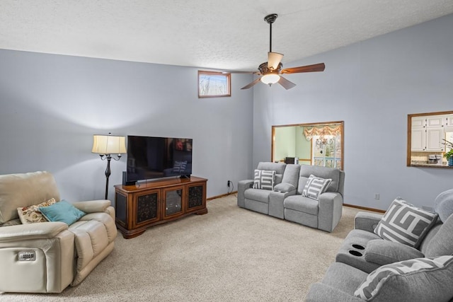 carpeted living room featuring a textured ceiling, ceiling fan, a high ceiling, and baseboards