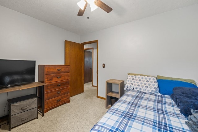 carpeted bedroom featuring a ceiling fan, a textured ceiling, and baseboards