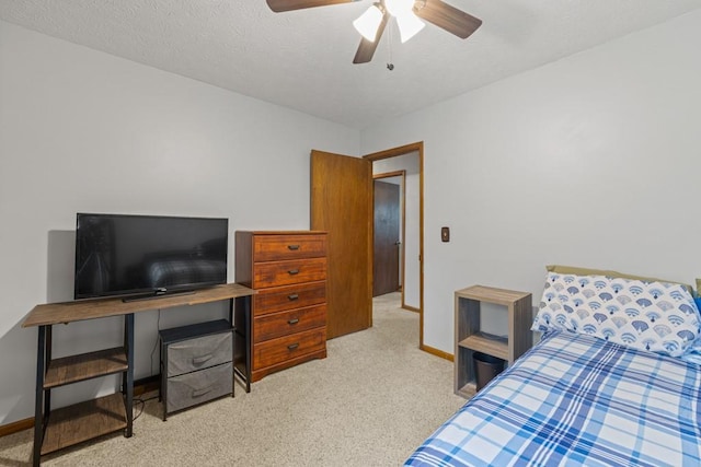 bedroom featuring carpet, baseboards, and a textured ceiling