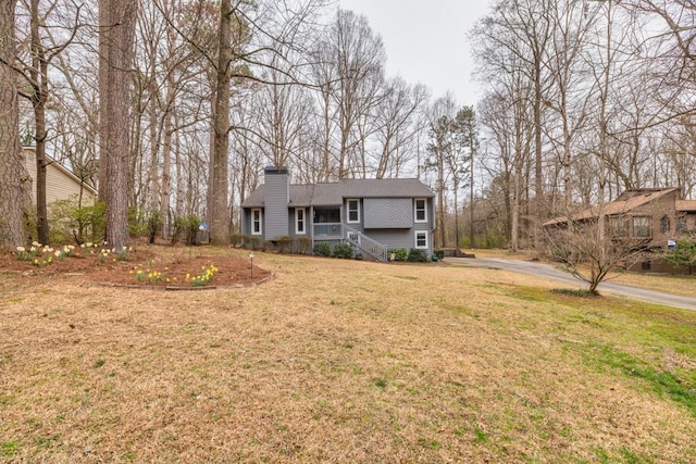 view of front of house with a chimney and a front lawn