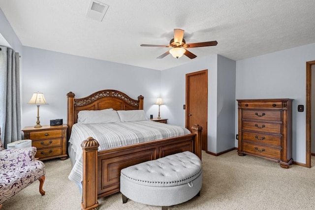 bedroom featuring baseboards, a textured ceiling, visible vents, and light colored carpet