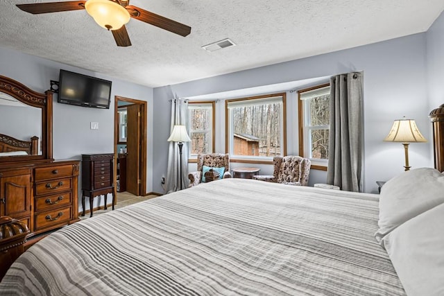 bedroom with ceiling fan, a textured ceiling, and visible vents