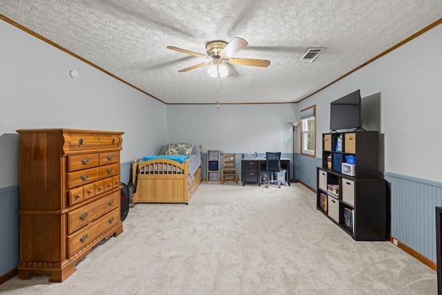 bedroom featuring a wainscoted wall, carpet, and a textured ceiling