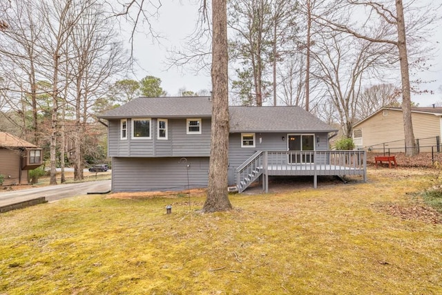 back of house featuring stairway, a wooden deck, fence, and a yard