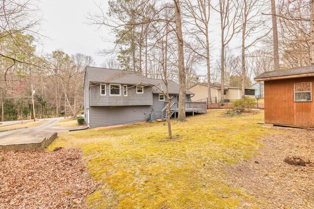 rear view of house featuring a yard and central air condition unit