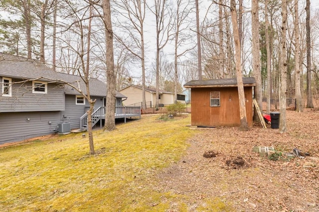 view of yard with an outdoor structure, a shed, a wooden deck, and central air condition unit