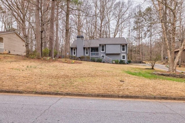 view of front of house with a chimney and a front lawn