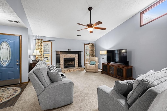 carpeted living area with vaulted ceiling, visible vents, plenty of natural light, and a textured ceiling