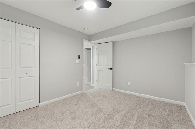 unfurnished bedroom featuring ceiling fan, a closet, and light carpet