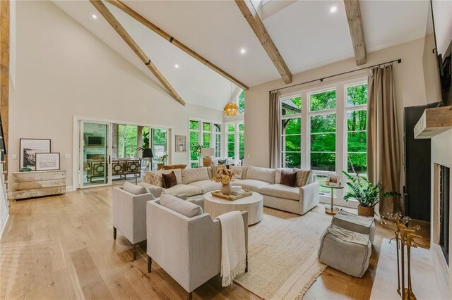 living room featuring beam ceiling, a fireplace, high vaulted ceiling, recessed lighting, and light wood-style flooring