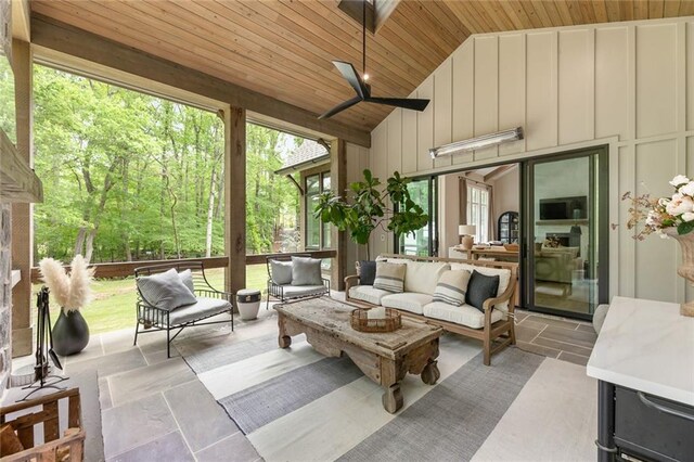 sunroom featuring ceiling fan and an outdoor living space
