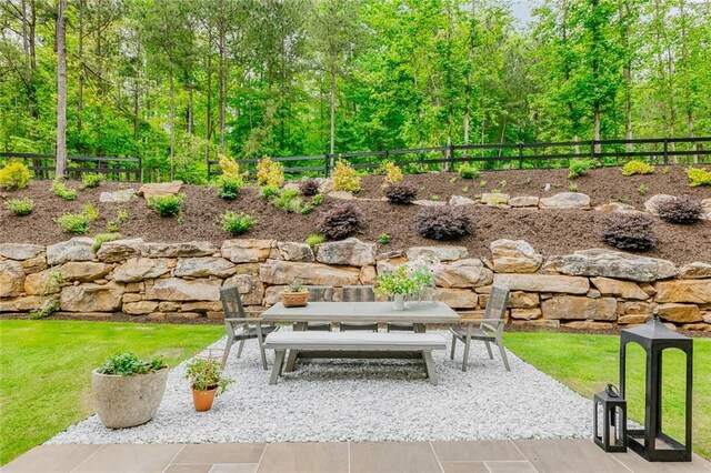 view of home's community with outdoor dining area, a fenced backyard, and a patio area