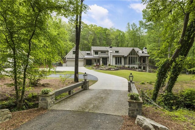 view of home's community with a yard and concrete driveway