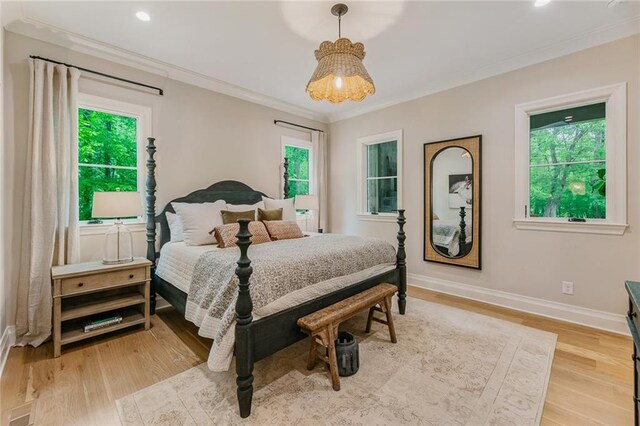 bedroom with crown molding, recessed lighting, baseboards, and wood finished floors