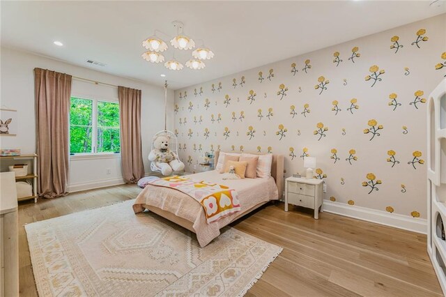 bedroom featuring baseboards, wallpapered walls, and light wood-style flooring