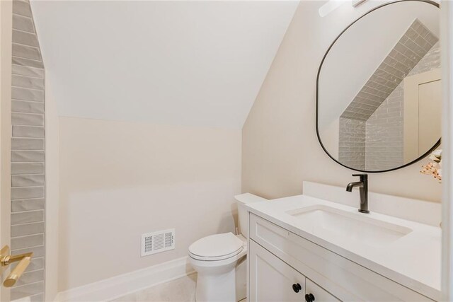 bathroom with visible vents, vanity, lofted ceiling, toilet, and baseboards