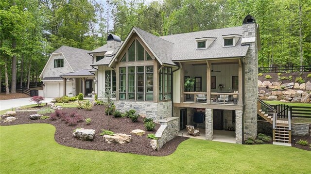 view of front of house with a chimney, roof with shingles, a sunroom, stairs, and stone siding