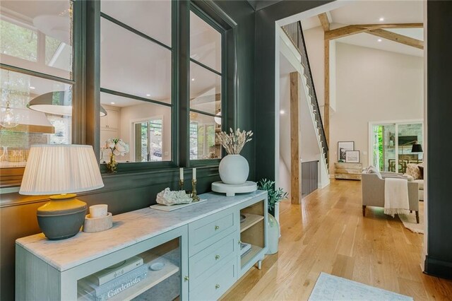 interior space featuring stairs, a high ceiling, and light wood-type flooring