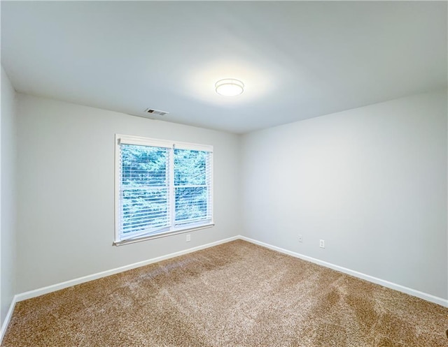 empty room featuring baseboards, carpet, and visible vents