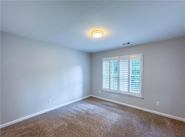 empty room with visible vents, baseboards, and carpet flooring