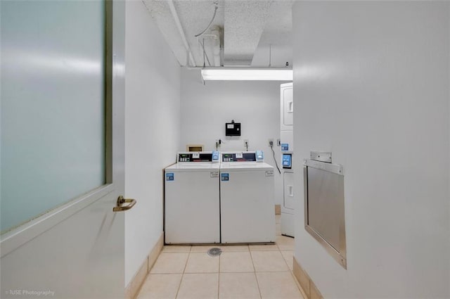 bathroom featuring stacked washer and dryer, tile patterned flooring, washing machine and dryer, and a textured ceiling