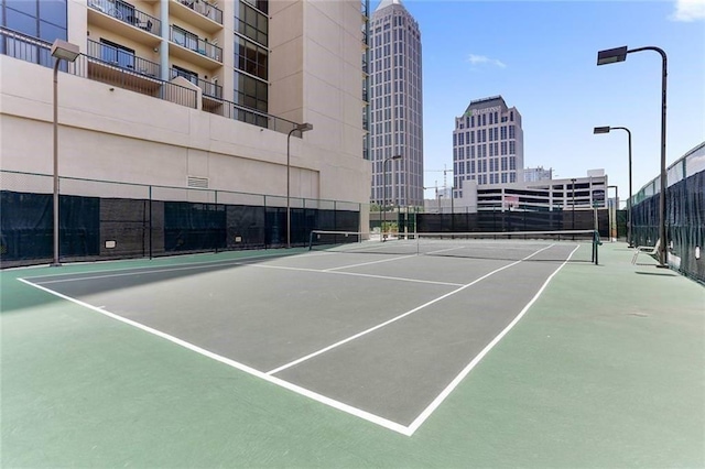 view of sport court with a view of city and fence