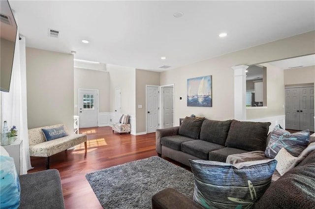 living room with decorative columns, recessed lighting, visible vents, and wood finished floors