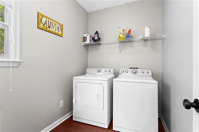laundry area featuring baseboards, laundry area, dark wood-style floors, and washer and clothes dryer