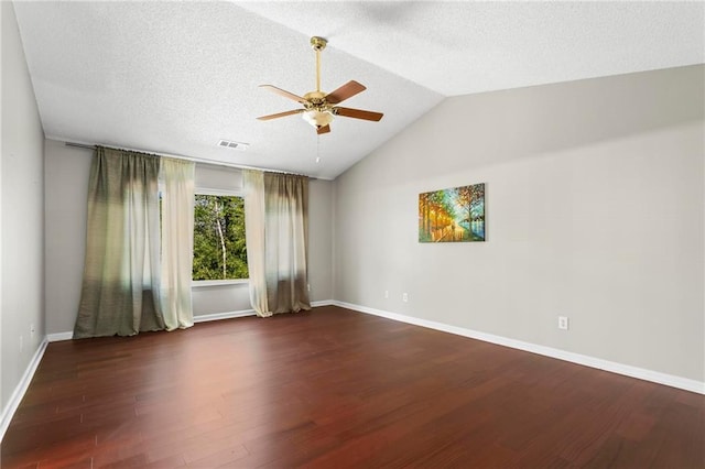 unfurnished room with a ceiling fan, visible vents, vaulted ceiling, wood finished floors, and baseboards