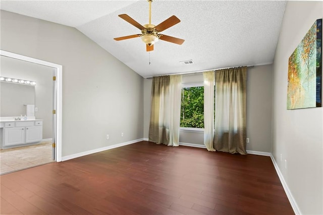 empty room featuring a ceiling fan, wood finished floors, and vaulted ceiling