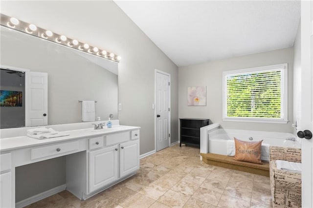 bathroom featuring a bath, lofted ceiling, and vanity