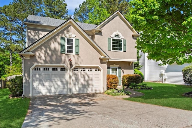 view of front of house featuring an attached garage, aphalt driveway, stucco siding, and a front yard