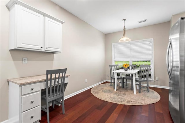 dining space with visible vents, dark wood-style flooring, baseboards, and built in study area