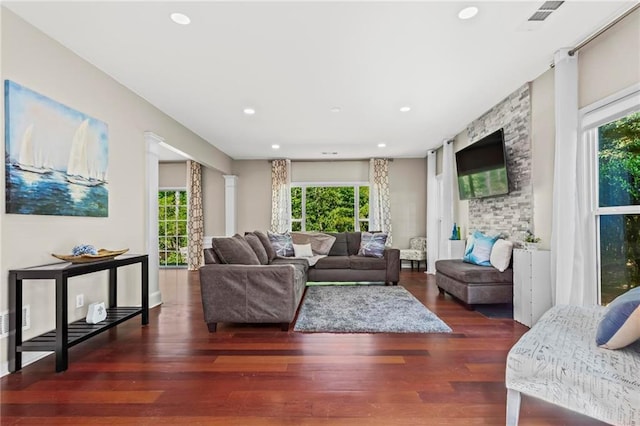 living room with recessed lighting, visible vents, and wood finished floors