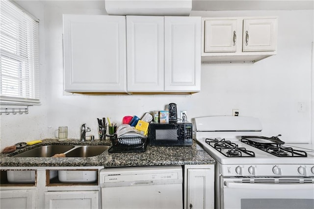 kitchen featuring dark stone countertops, sink, white appliances, and white cabinets