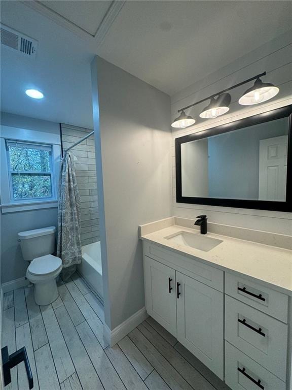 full bathroom with hardwood / wood-style flooring, vanity, shower / bath combo, and toilet