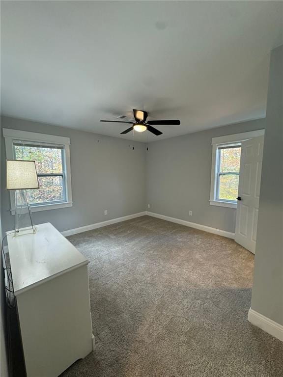 empty room with carpet, ceiling fan, and a wealth of natural light