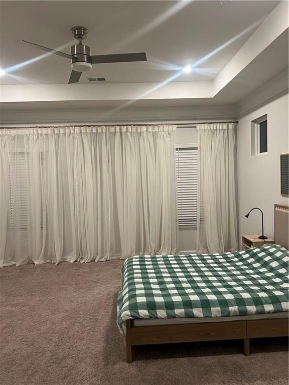 carpeted bedroom with visible vents and a ceiling fan