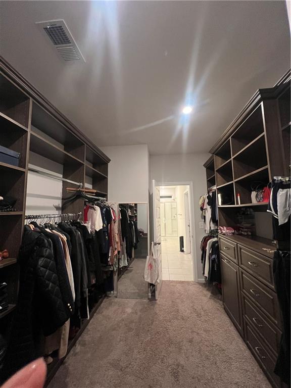 walk in closet featuring carpet flooring and visible vents