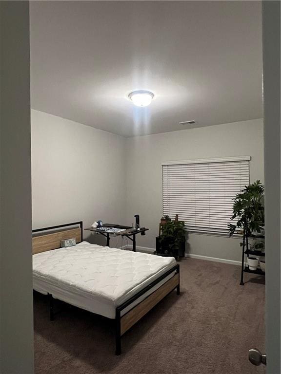 carpeted bedroom featuring visible vents and baseboards