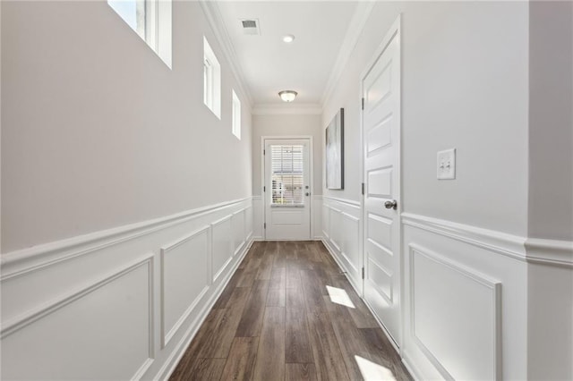 entryway featuring ornamental molding, dark wood-type flooring, wainscoting, and visible vents