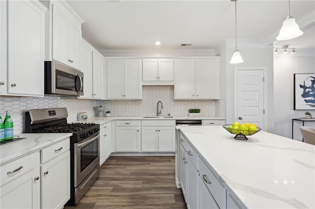 kitchen with crown molding, appliances with stainless steel finishes, dark wood-type flooring, white cabinets, and a sink