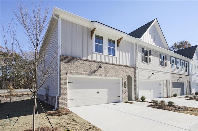 view of side of property with driveway, brick siding, board and batten siding, and an attached garage